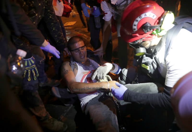 FILE PHOTO: An injured demonstrator is attended by paramedics during a clash with police during a protest against the decision of Congress to remove former President Martin Vizcarra, in Lima