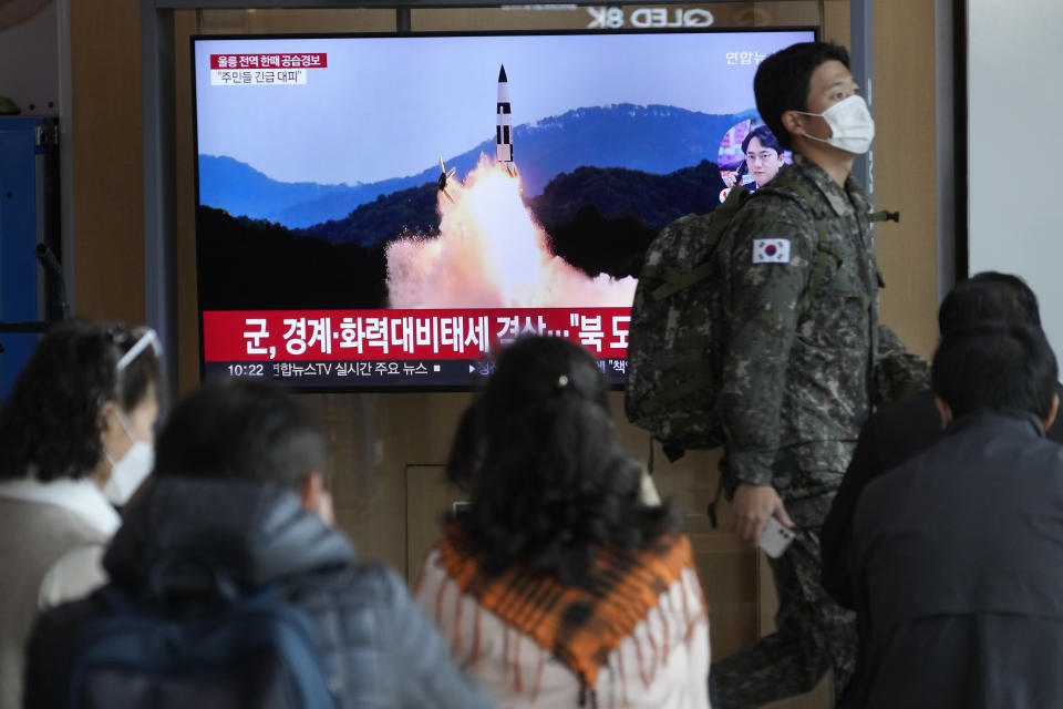A South Korean army soldier passes by a TV screen showing a file image of North Korea's missile launch during a news program at the Seoul Railway Station in Seoul, South Korea, Wednesday, Nov. 2, 2022. South Korea says it has issued an air raid alert for residents on an island off its eastern coast after North Korea fired a few missiles toward the sea. (AP Photo/Ahn Young-joon)