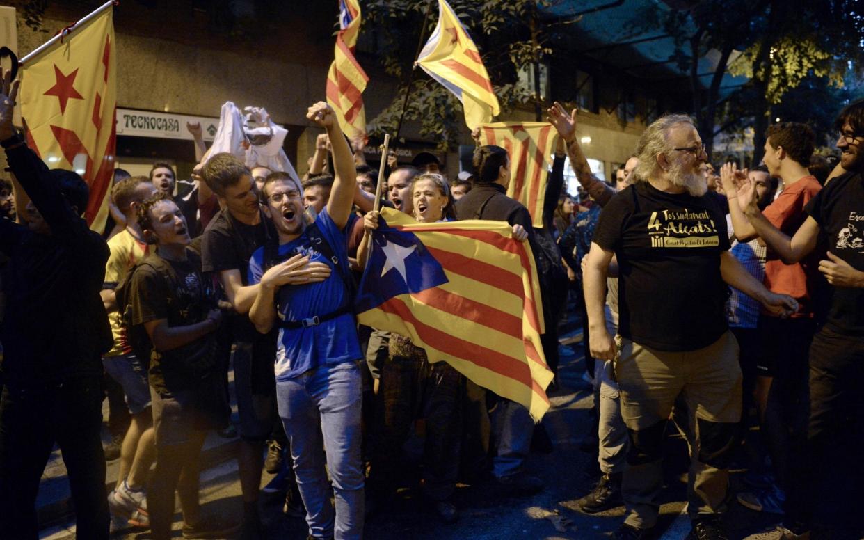 Pro-referendum demonstrators protest in front of Spanish National Police officers - AFP