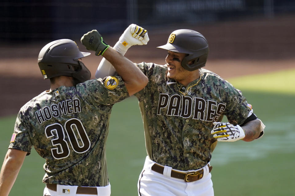 San Diego Padres' Manny Machado, right, reacts with teammate Eric Hosmer after hitting a home run during the first inning of a baseball game against the Seattle Mariners, Thursday, Aug. 27, 2020, in San Diego. (AP Photo/Gregory Bull)