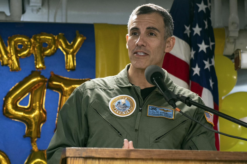 In this Oct. 15, 2019, photo provided by the U.S. Navy, Capt. Carlos Sardiello, who was then the commanding officer of the aircraft carrier USS Theodore Roosevelt (CVN 71), addresses sailors during the 244th Navy birthday celebration on the mess decks during a home port visit in San Diego. Sardiello was called on to step in as commander of the Roosevelt after Capt. Brett Crozier was fired for sending an email pleading with commander to act more quickly to address the growing outbreak on the ship. (Petty Officer 3rd Class Zachary Wheeler/U.S. Navy via AP)