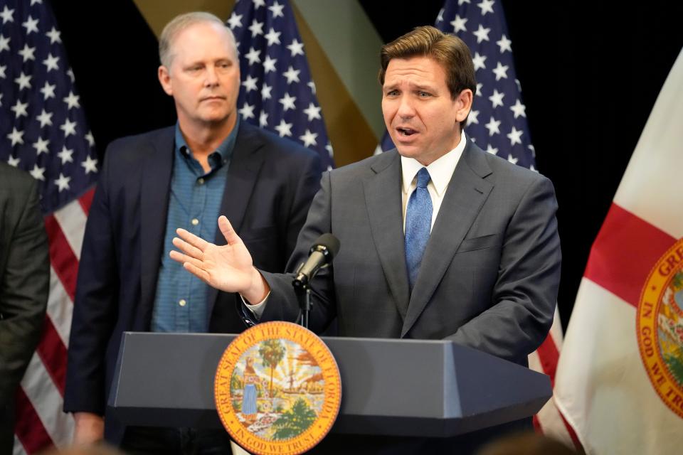 Florida Gov. Ron DeSantis, right, speaks at a news conference as Wilton Simpson, Commissioner of Agriculture listens, at the Reedy Creek Administration Building Monday, April 17, 2023, in Lake Buena Vista. DeSantis and Florida lawmakers ratcheted up pressure on Walt Disney World on Monday by announcing legislation that will use the regulatory powers of Florida government to exert unprecedented oversight on the park resort's rides and monorail. (AP Photo/John Raoux) ORG XMIT: FLJR104