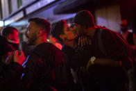 Late-night drinkers in Soho gather on the street in the early hours of Sunday, July 5, 2020, in London, as coronavirus lockdown restrictions eased across the country. England embarked on perhaps its biggest lockdown easing yet as pubs and restaurants reopened for the first time in more than three months. (Victoria Jones/PA via AP)