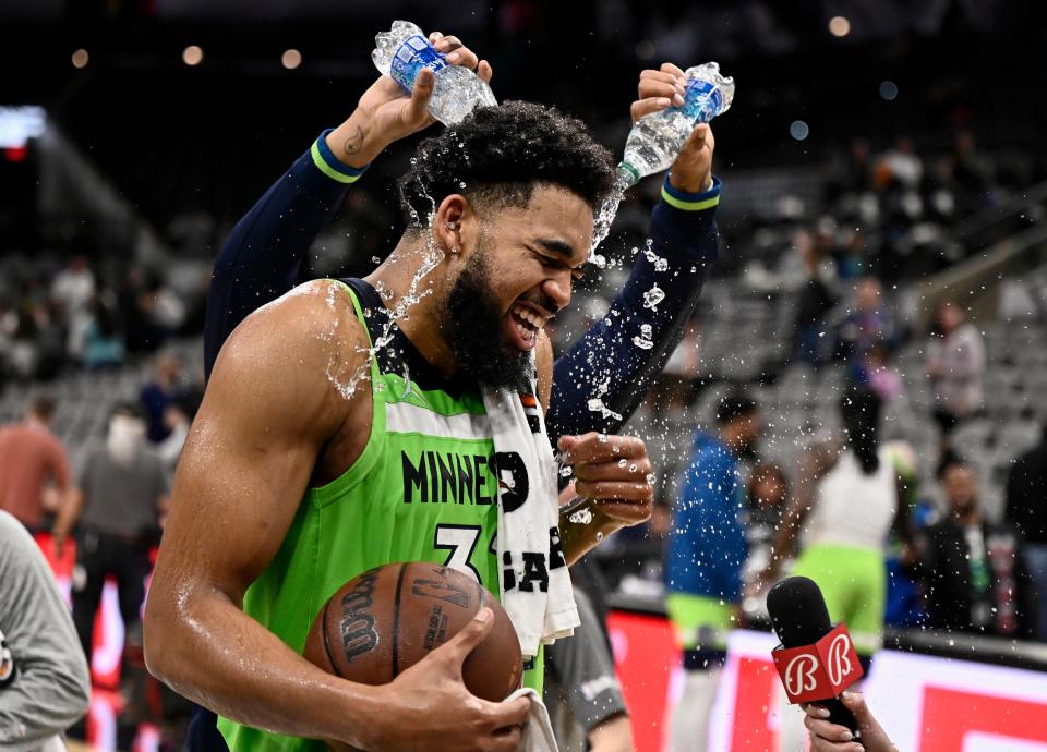 Karl-Anthony Towns is doused by teammate D'Angelo Russell (rear) after his 60-point game against the Spurs last month.