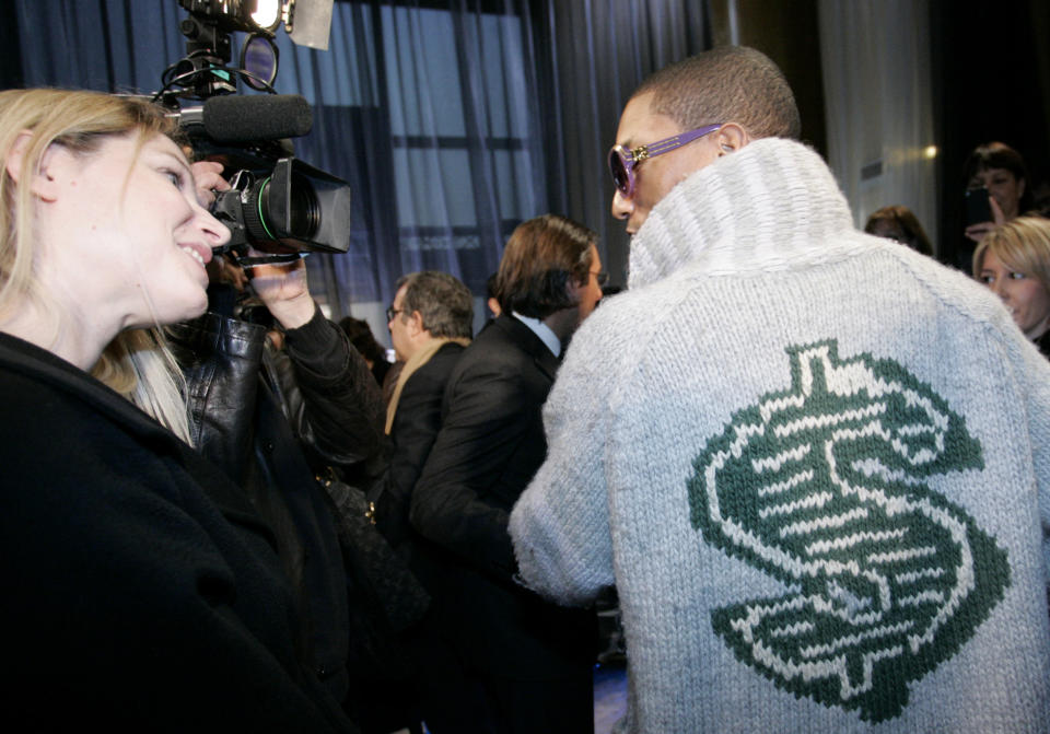 FILE - U.S rap artist Pharrell Williams, right, talks with an unidentified journalist after the presentation of Louis Vuitton men's fall/winter 2008-2009 fashion collection in Paris, Jan.17, 2008. The signs of hip-hop’s influence are now everywhere from Pharrell Williams becoming Louis Vuitton’s men’s creative director to billion-dollar brands like Dr. Dre’s Beats headphones and retail mainstays like Diddy’s Sean John and the Rocawear line started by Jay-Z. It didn’t start out that way. Companies at first balked at partnering with hip-hop acts because they felt that the genre that appealed to Black and brown teens and young adults didn't align with their brands. (AP Photo/Thibault Camus, file)