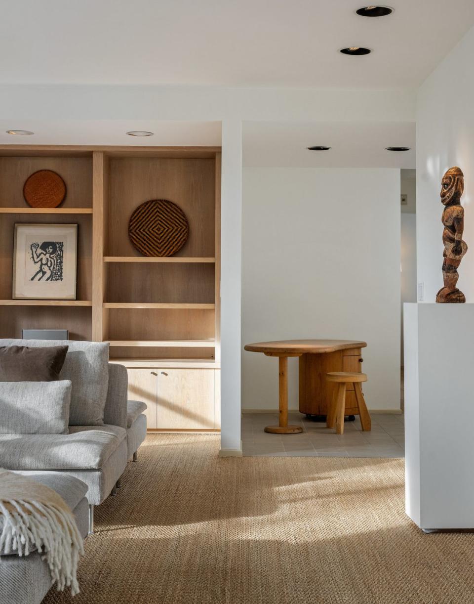 a living room with a shelf and a table