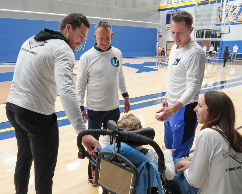 Milwaukee Bucks guard Pat Connaughton, left, greets 7-year-old Ricky Witte at the kickoff kickoff event for a Make-A-Wish Wisconsin fundraiser on Thursday, January 19, 2023, at Mukwonago High School in Mukwonago, Wisconsin. Ricky is the son of girls basketball coach Rick Witte, upper right, and his wife, Laura. Jerry Jendusa, who spearheads the fundraiser, stands between Connaughton and Rick Witte.