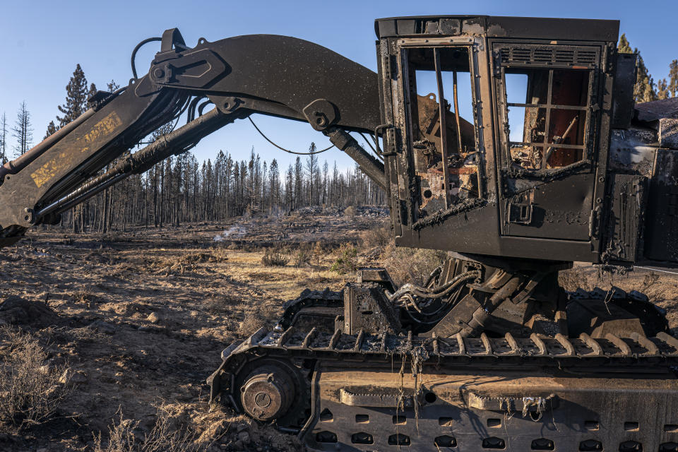 A damaged and abandoned excavator is seen in an area burned by the Bootleg Fire on Wednesday, July 21, 2021 in Bly, Ore. (AP Photo/Nathan Howard)