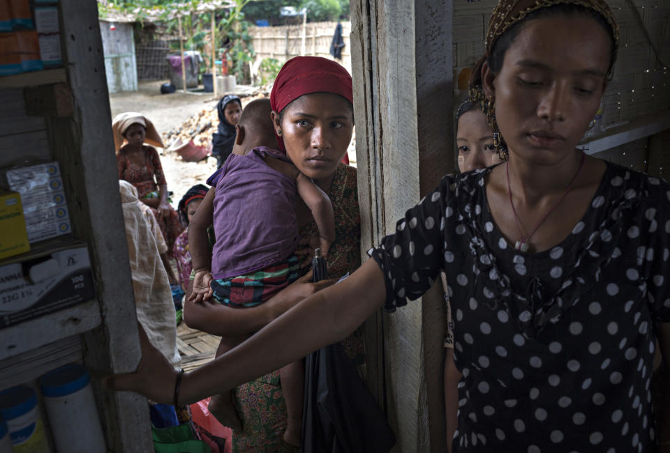 SITTWE, BURMA - MAY 06: Women line up at the door of a makeshift pharmecy and clinic in the Thet Kae Pyin refugee camp. Most complain of fevers and stomach aches. Some are pregnant and many people suffer from dehydration and malnutrition on May 6, 2014 in Sittwe, Burma. Some 150,000 Rohingya IDP (internally displaced people) are currently imprisoned in refugee camps outside of Sittwe in Rakhine State in Western Myanmar. Medecins Sans Frontieres (MSF), the primary supplier of medical care within the camps, was banned in March by the Myanmar government. Follow up attacks by Buddhist mobs on the homes of aid workers in Sittwe put an end to NGO operations in the camps. Though some NGOs are beginning to resume work, MSF remains banned, and little to no healthcare is being provided to most Rohingya IDPs. One Rohingya doctor is servicing 150,000 refugees with limited medication. Several Rakhine volunteer doctors sporadically enter the camps for two hours a day. Births are the most complicated procedures successfully carried out in the camps, requests to visit Yangon or Sittwe hospitals for life threatening situations require lengthy applications and are routinely denied. Malnutrition and diarrhea are the most widespread issues, but more serious diseases like tuberculosis are going untreated and could lead to the rise of drug resistant tuberculosis (DR-TB).  (Photo by Andre Malerba/Getty Images)