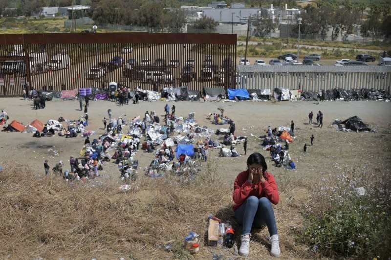 Migrants wait between the primary and secondary fencing at the Tijuana, Mexico-San Diego border for the end of Title 42 in May. File Photo by Carlos Moreno/UPI