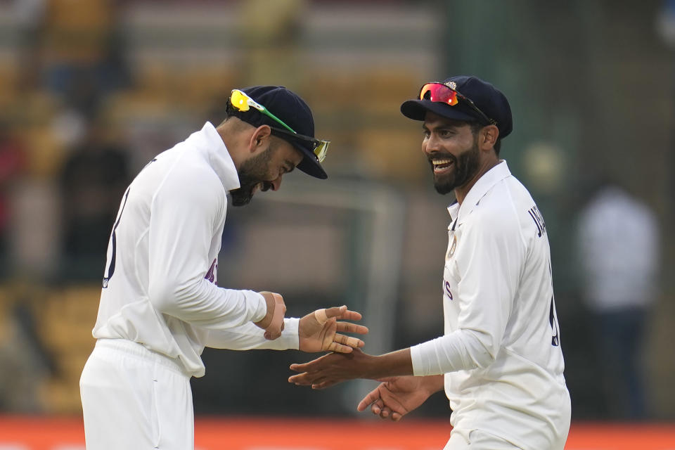 India's Virat Kohli, left, and Ravindra Jadeja share a light moment during the third day of the second cricket test match between India and Sri Lanka in Bengaluru, India, Monday, March 14, 2022. (AP Photo/Aijaz Rahi)