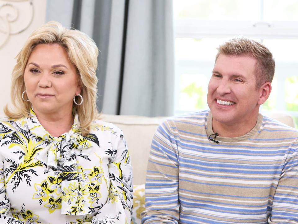 Julie Chrisley in a floral top and Todd Chrisley in a striped shirt