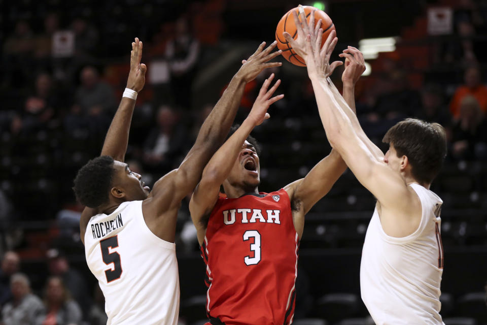 Utah forward Bostyn Holt, center, has his shot blocked as Oregon State's Justin Rochelin, left, and Dzmitry Ryuny, right, defend during the second half of an NCAA college basketball game in Corvallis, Ore., Thursday, Jan. 26, 2023. Utah won 63-44. (AP Photo/Amanda Loman)