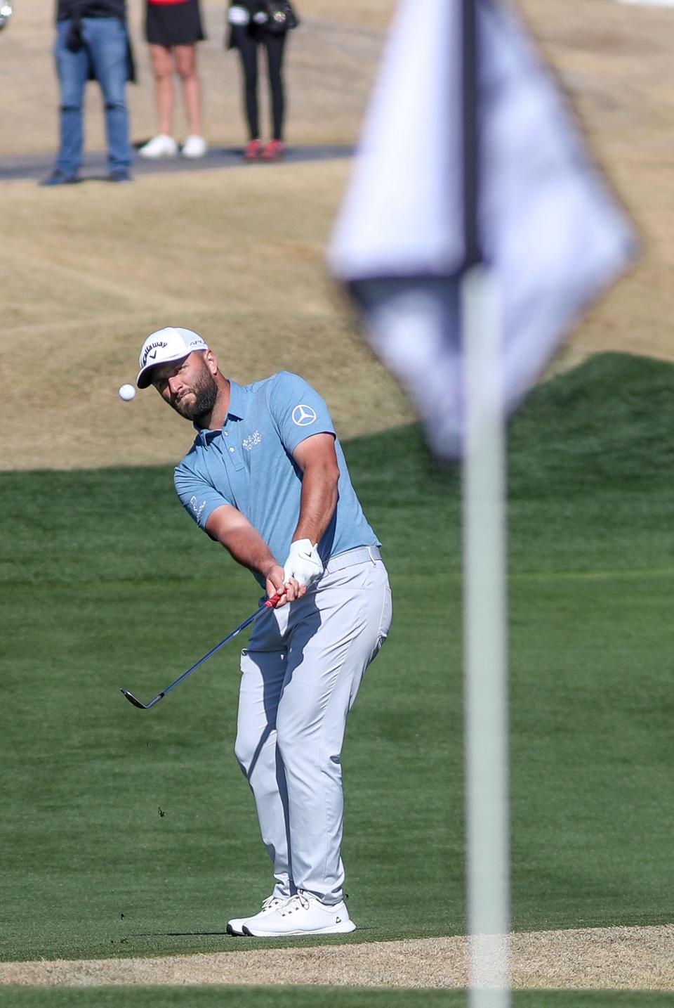 Jon Rahm hits his third shot on the par 5 eighth hole at the Pete Dye Stadium Course at PGA West during The American Express in La Quinta, Calif., Jan. 21, 2023. 