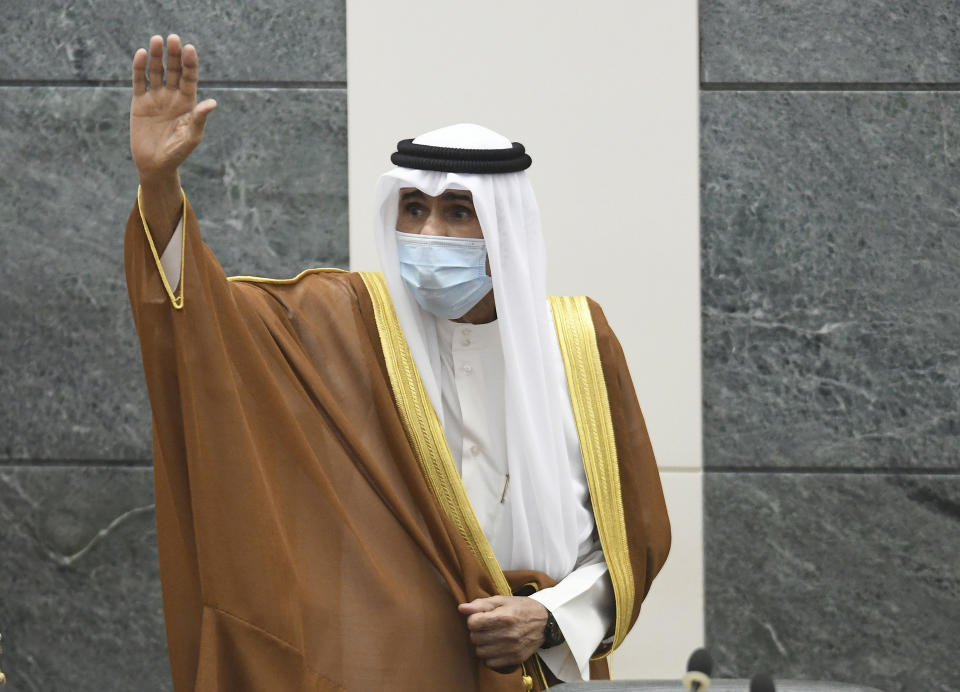 FILE - In this Sept. 30, 2020 file photo, the new Emir of Kuwait Sheikh Nawaf Al Ahmad Al Sabah, waves after he was sworn in at the Kuwaiti National Assembly. Kuwait, one of the world’s wealthiest countries, is facing a debt crisis as a parliamentary election looms in December. It needs the new parliament to approve raising its debt spending and passing the bill will be the first legislative challenge for the new emir. (AP Photo/Jaber Abdulkhaleg, File)