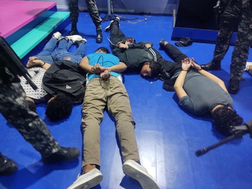 People accused of invading and taking over television station TC with weapons and forcing staff to lie and sit down, lie handcuffed on the floor in a police haundout, in Guayaquil, Ecuador,