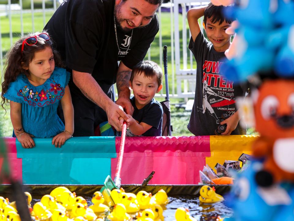 Paul Olvera of Indio helps his 2-year-old son, Alexander, fish for a rubber duck for a prize during the Taste of Jalisco Festival in Cathedral City, Calif., Saturday, Feb. 4, 2023. 