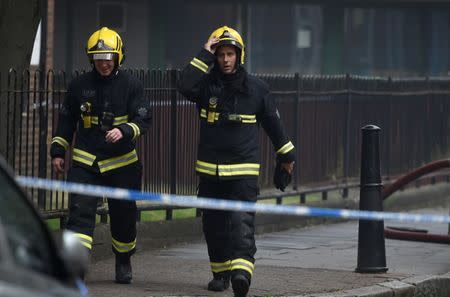 Firefighters walk near a fire at a low-rise block of buildings in Bethnal Green, northeast London, Britain, June 24, 2017. REUTERS/Hannah McKay