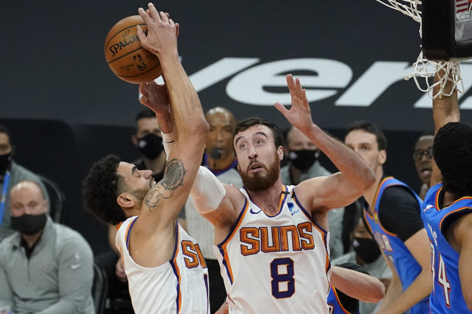 Phoenix Suns forward Frank Kaminsky (8) and forward Abdel Nader battle for a rebound against the Oklahoma City Thunder during the first half of an NBA basketball game, Wednesday, Jan. 27, 2021, in Phoenix. (AP Photo/Matt York)