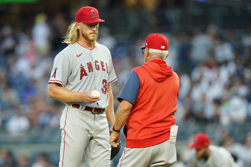 Los Angeles Angels starting pitcher Noah Syndergaard hands the ball to manager Joe Maddon during the third inning of a baseball game against the New York Yankees Tuesday, May 31, 2022, in New York. (AP Photo/Frank Franklin II)