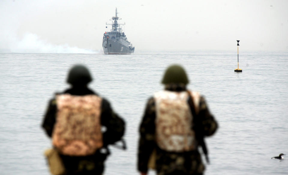Ukrainian marines look at a Russian ship in Sevastopol Bay.