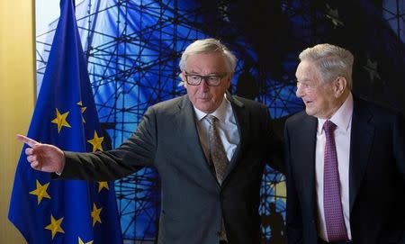 FILE PHOTO: EU Commission President Jean-Claude Juncker (L) meets U.S. financier George Soros as part of consultations on a new Hungarian law that has threatened to force the closure of a university he funds prior to a meeting in Brussels, Belgium, April 27, 2017. REUTERS/Olivier Hoslet/Pool