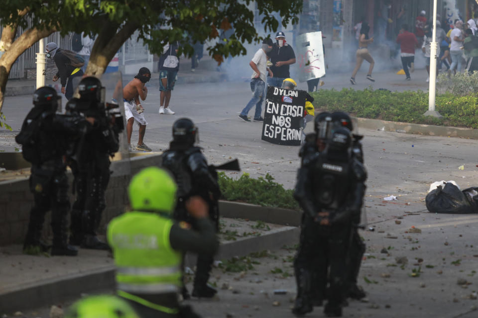 Police clash with anti-government demonstrators protesting against the FIFA World Cup Qatar 2022 qualifying soccer match between Argentina and Colombia in Barranquilla, Colombia, Tuesday, June 8, 2021. (AP Photo/Jairo Cassiani)