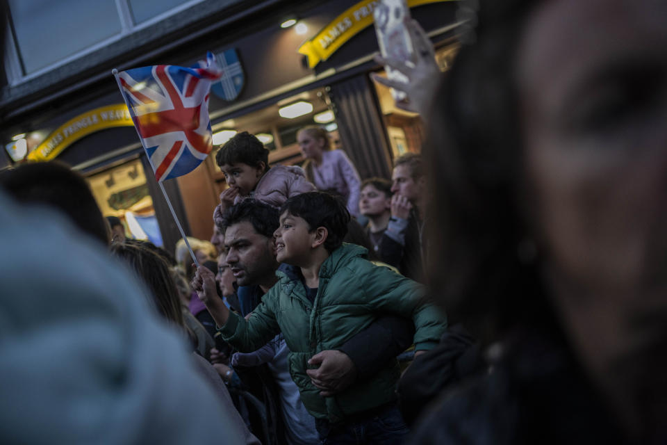 A child waves the Union Jack flag during the arrival of King Charles III at St Giles Cathedral where the coffin of Queen Elizabeth II lies at rest in Edinburgh, Scotland, Monday, Sept. 12, 2022. Britain's longest-reigning monarch who was a rock of stability across much of a turbulent century, died Sept. 8, after 70 years on the throne. She was 96. (AP Photo/Bernat Armangue)