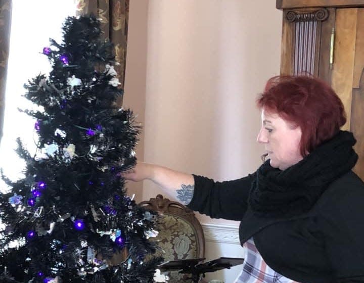 Michelle Murrills decorates a Ghosts of Centre Hill-themed tree for the 2023 Centre Hill Holiday Showcase in Petersburg.