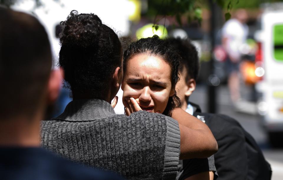 People comfort each other in the immediate aftermath of the fire (Rex)