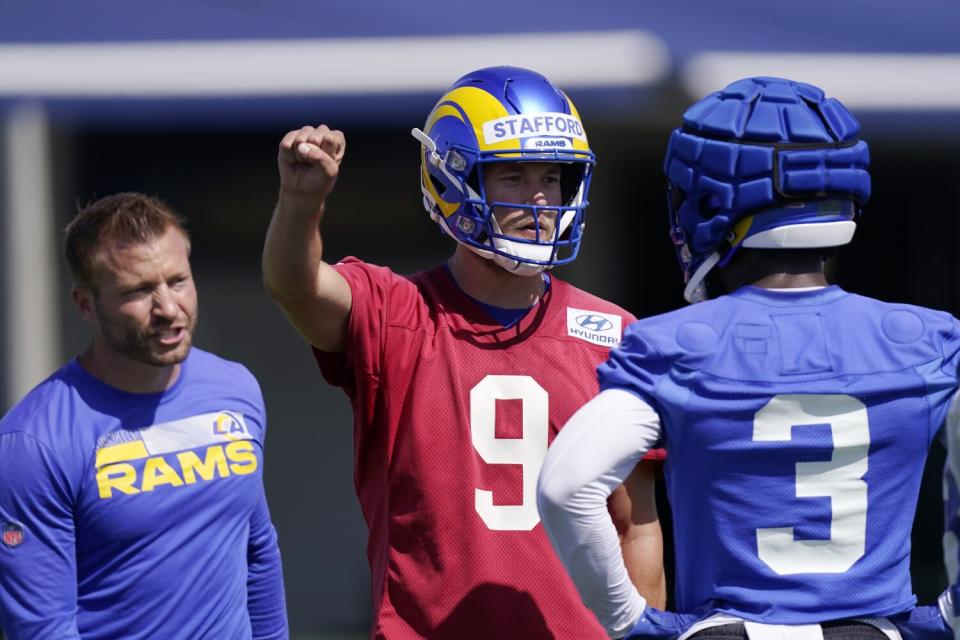 Rams quarterback Matthew Stafford signals as running back Cam Akers (3) listens to coach Sean McVay.