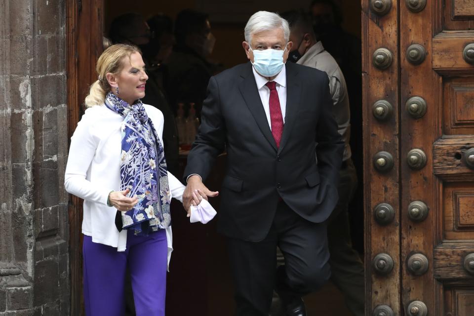 Mexican President Andres Manuel Lopez Obrador, right, wearing protective face masks to help curb the spread of the coronavirus, and first lady Beatriz Gutierrez walk away after voting in Mexico City, Sunday, June 6, 2021. Mexicans on Sunday were electing the entire lower house of Congress, almost half the country's governors and most mayors in a vote that will determine if Obrador's Morena party gets a legislative majority. (AP Photo/Marco Ugarte)