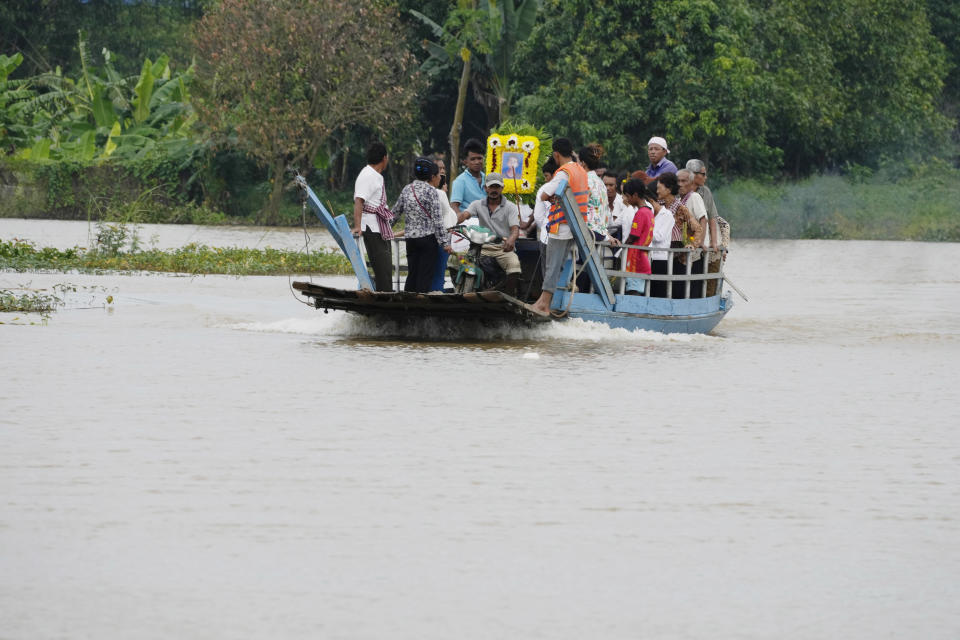 CORRECTS TO SAY EAST OF PHNOM PENH, NOT EASTERN - The coffin of Son Sophat, a teen victim of a boat accident, is carried in a wooden boat during a funeral procession in Koh Chamroeun village, east of Phnom Penh, Cambodia, Friday, Oct. 14, 2022. Multiple students in southern Cambodia who were crossing a river have died after the boat they were on capsized Thursday night, officials said. (AP Photo/Heng Sinith)