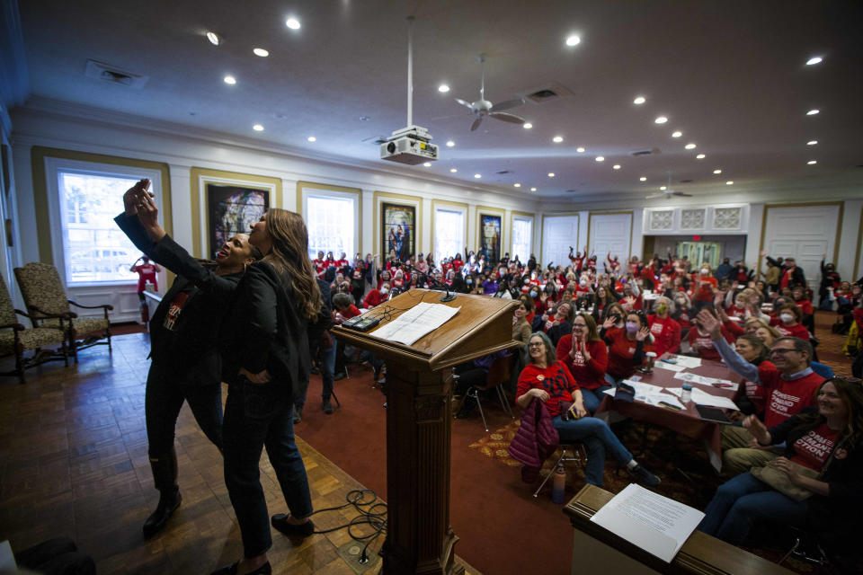 Guest Speakers Angela Ferrell-Zabala and Shannon Watts take a selfie with the volunteers of Moms Demand Action during the Call for Action on Gun Safety rally Friday Jan. 13, 2023 inside St. Paul's Episcopal Church in Richmond, Va. Moms Demand Action also celebrated it's 10 year anniversary during the rally. (AP Photo/John C. Clark)