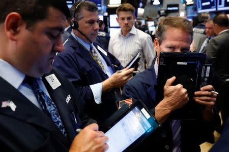 FILE PHOTO: Traders work on the floor of the New York Stock Exchange in New York, U.S., June 27, 2017. REUTERS/Lucas Jackson