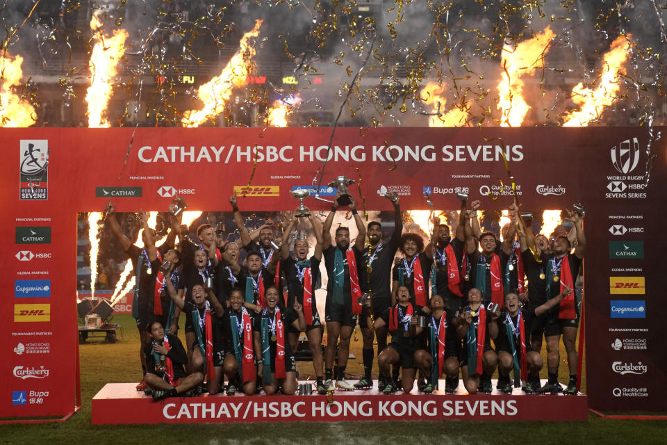 New Zealand's players celebrate with their trophies after winning the men's and women's Hong Kong Sevens rugby tournament in Hong Kong, Sunday, April 2, 2023. (AP Photo/Louise Delmotte)