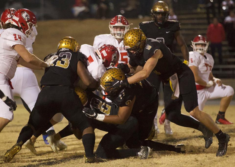 A host of Shelby tacklers converge on an East Surry ball carrier during Friday's game.
