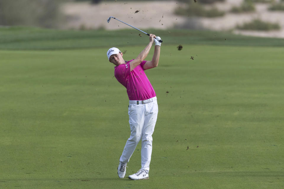 Matthew Fitzpatrick of England hits his second shot on the 14th hole during round two of the Dubai Desert Classic golf tournament in Dubai, United Arab Emirates, Friday, Jan. 25, 2019. (AP Photo/Neville Hopwood)