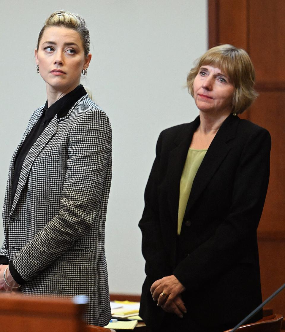 US actress Amber Heard (C) stands with a legal team member and her attorney, Elaine Bredehoft