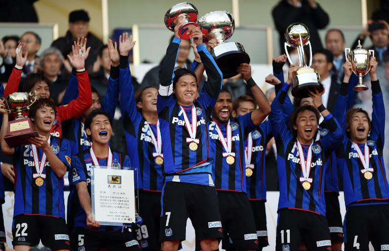 Gamba Osaka players celebrate on the podium after their victory over Montedio Yamagata, at the Emperor's Cup football tournament in Yokohama, on December 13, 2014