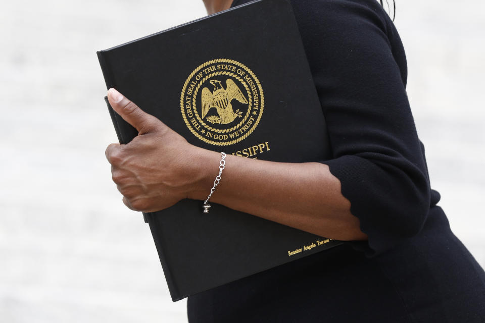 Sen. Angela Turner Ford, D-West Point, chairwoman of the Mississippi Legislative Black Caucus, holds her Legislative portfolio after commenting on the passage by the Legislature of legislation to take down and replace the current state flag which contains the Confederate battle emblem, during a news conference at the Capitol in Jackson, Miss., Monday, June 29, 2020, (AP Photo/Rogelio V. Solis)