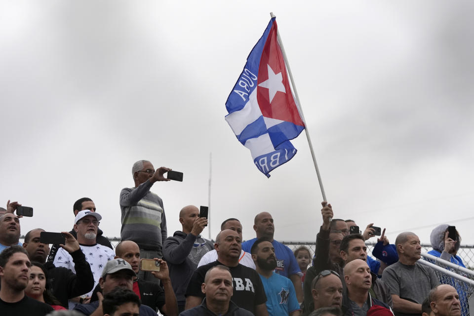 Fanáticos cantan el himno nacional de Cuba antes de un juego de exhibición del equipo denominado Federación Profesional Cubana de Beisbol (FEPCUBE) ante el Miami Dade College, el 17 de enero de 2024 (AP Foto/Wilfredo Lee)