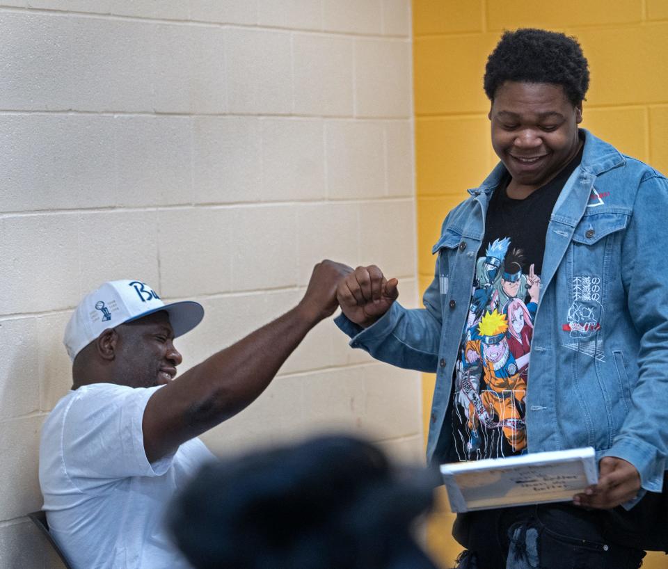 Joe Rush, left, fist bumps Tristan Flint after Flint presented his vision board Friday, Oct. 27, 2023 at the Boys & Girls Club. The vision boards show partispants’ plans to change their fixed mindset to a growth mindset. The far eastside club has a program, the Pivot Re-Engagement Center’s Power Huddle, that aims to engage young men aged 16-24 who are out of school and out of work. The program works to find local solutions, funded by city grants, to prevent gun violence.