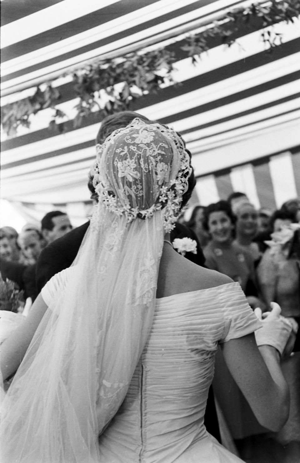 View from behind of Jacqueline Kennedy (1929 - 1994) (in a Battenburg wedding dress) as she dances with her husband, future US President John F Kennedy (1917 - 1963) at their wedding reception, Newport, Rhode Island, September 12, 1953. (Photo by Lisa Larsen/Time & Life Pictures/Getty Images)