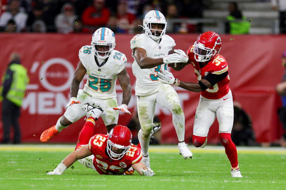 Nov 5, 2023; Frankfurt, Germany, ; Miami Dolphins running back Raheem Mostert (31) breaks a tackle from Kansas City Chiefs linebacker Nick Bolton (32) and cornerback Jaylen Watson (35) in the fourth quarter during an NFL International Series game at Deutsche Bank Park. Mandatory Credit: Nathan Ray Seebeck-USA TODAY Sports