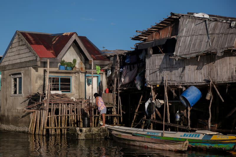 The Wider Image: Rising seas threaten early end for sinking village in Philippines