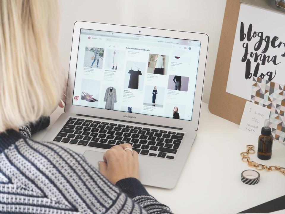 A Pinterest user perusing its website with her laptop.