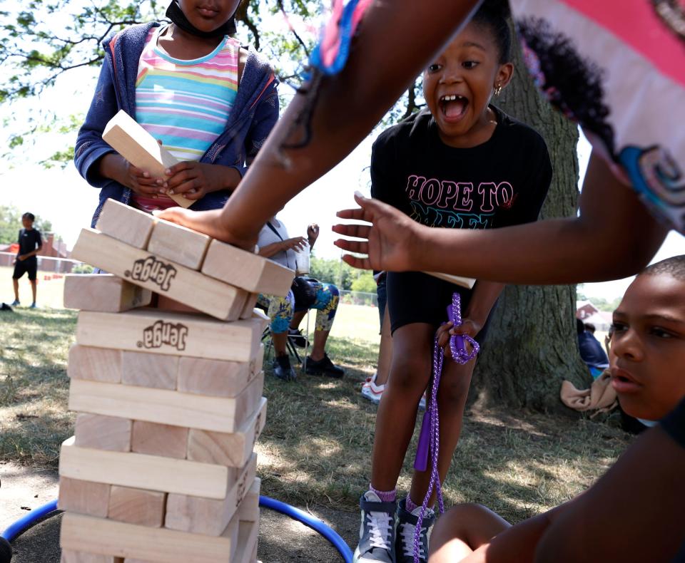 Pieper Hammond, 7, of Detroit, right, reacts with other campers while playing Jenga during the What's Good In My Hood Outdoor Adventure Camp at the Tindal Recreation Center in Detroit on Thursday, June 30, 2022.