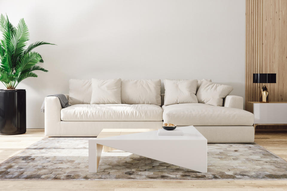 A clean and modern living room with a large sofa and a coffee table