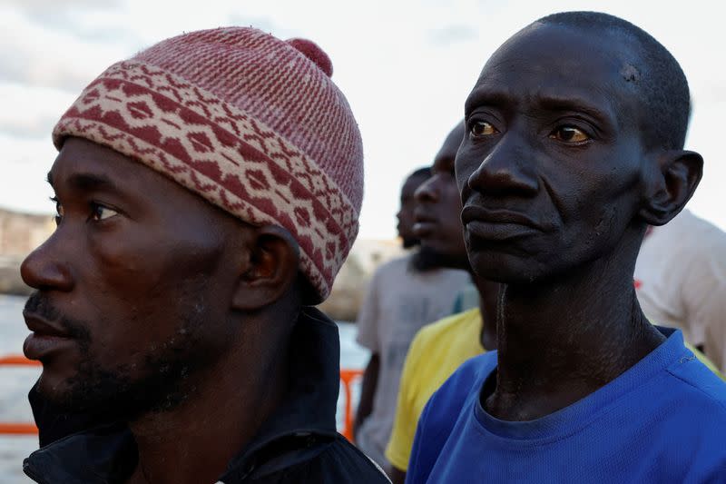 Migrants wait to disembark from a Spanish coast guard vessel in port of Arguineguin